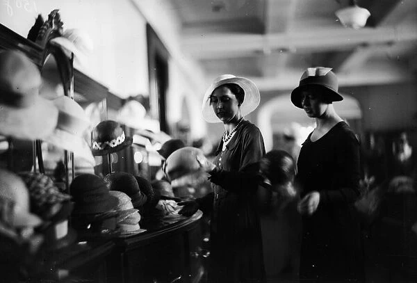 A New Hat. circa 1928: Shopping for hats in a department store