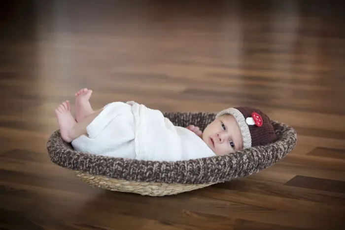 Framed Print : Newborn baby, 3 weeks, wearing a hat, lying in a basket