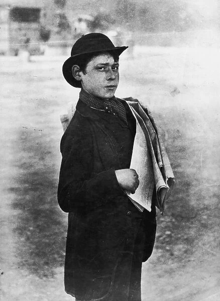 News Boy. circa 1900: A London news boy selling copies of a newspaper