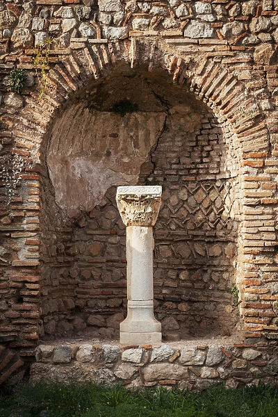 Niche in a stone wall with column and capitol