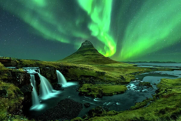northern lights appear over Mount Kirkjufell with kirkjufellfoss waterfall in Iceland