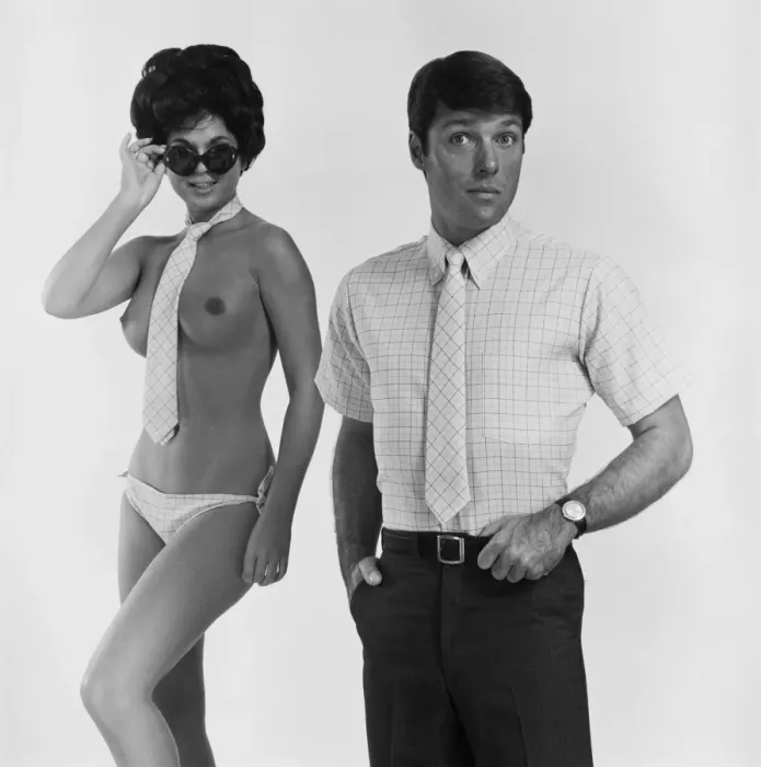 Framed Print : Nude woman wearing tie and sunglasses standing beside man Framed Print : Nude woman wearing tie and sunglasses standing beside man