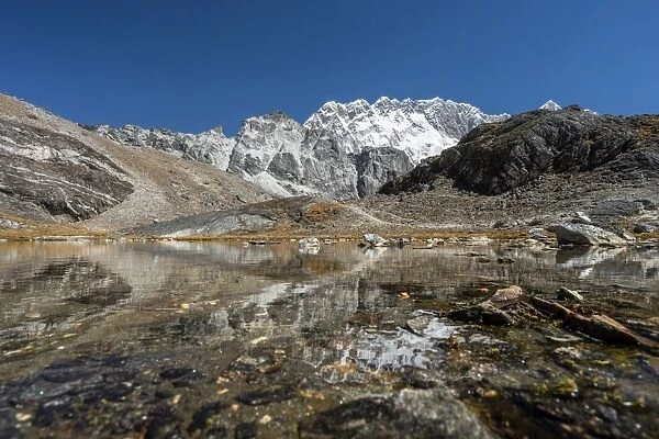 Nuptse mountain and small lake reflection, Everest region