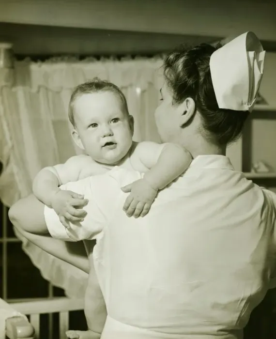 Framed Print : Nurse holding baby boy (6-12 months), (B&W)