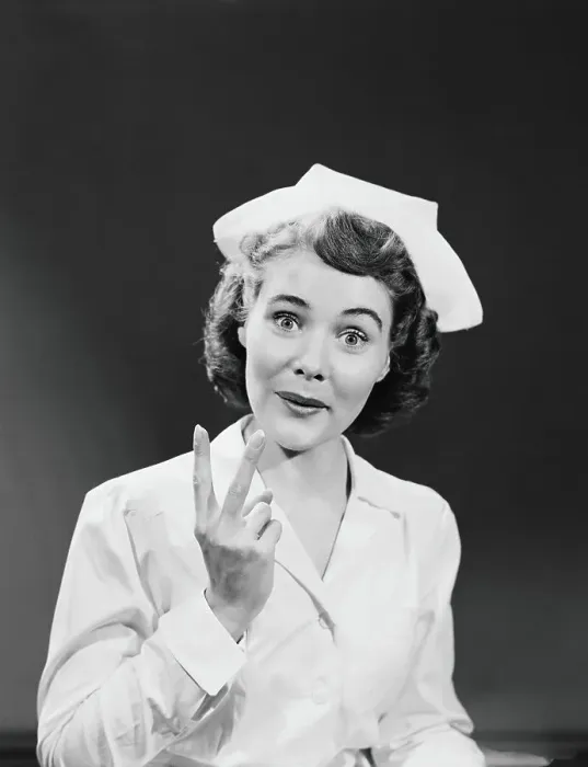 Framed Print : Nurse holding up two fingers signifying arrival of twin babies, portrait Framed Print : Nurse holding up two fingers signifying arrival of twin babies, portrait