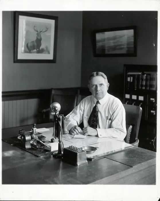 Framed Print : Office Manager At Desk Looking At Camera Framed Print : Office Manager At Desk Looking At Camera