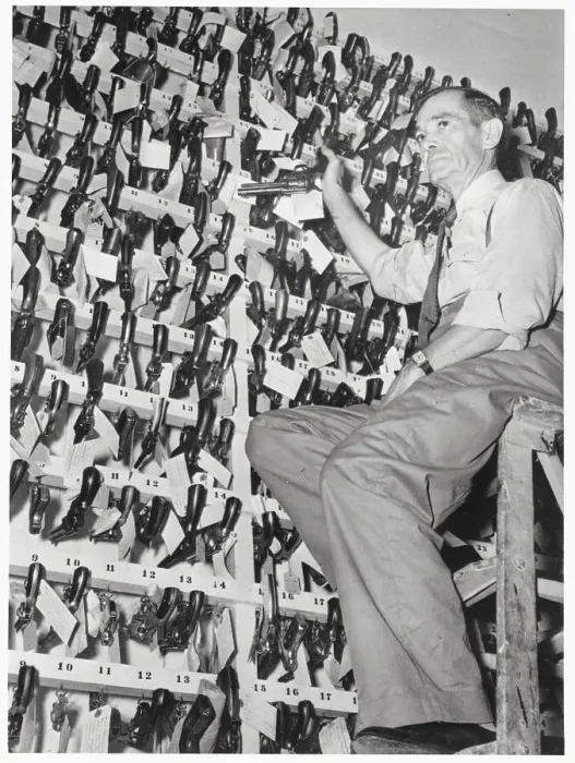 Framed Print : Officer Posing with Confiscated Guns Framed Print : Officer Posing with Confiscated Guns