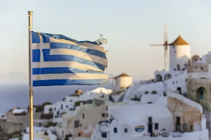 Framed Print : Oia village in Santorini and flag of Greece Framed Print : Oia village in Santorini and flag of Greece