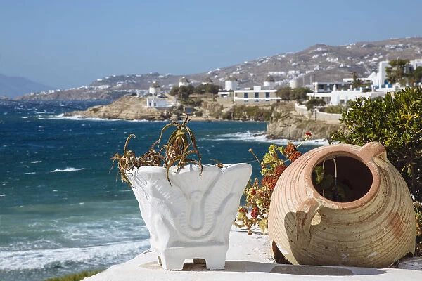 Old flower pots on foreground and Mykonos town and Aegean sea in the background, Cyclades, Greece