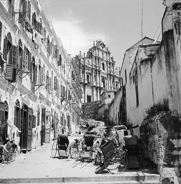 Old Macao. circa 1950: Rickshaws in a street in the old quarter of the