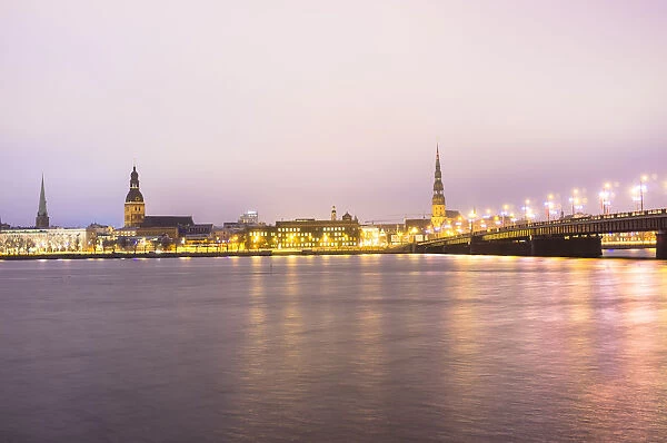 Old Riga skyline at dusk and Akmens bridge over Daugava river. Riga, Latvia