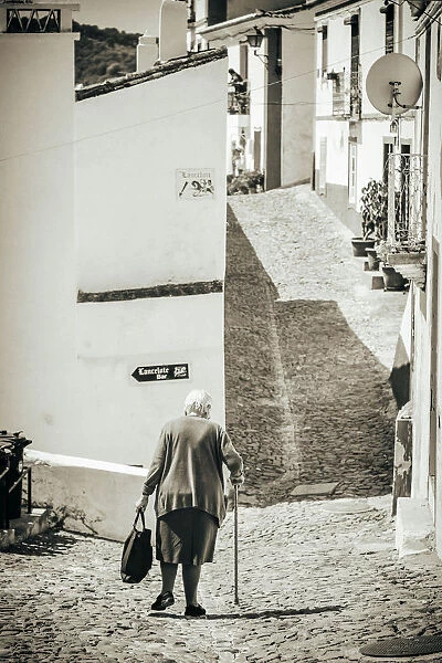 Old woman walks in the road