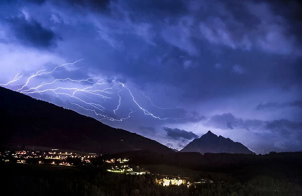 Ominous clouds and lightning bolts from thunderclouds over the Stubai Valley near Innsbruck, in the back Mt. Serles and Aldrans and Lans villages, night scene, Innsbruck, Tyrol, Austria, Europe