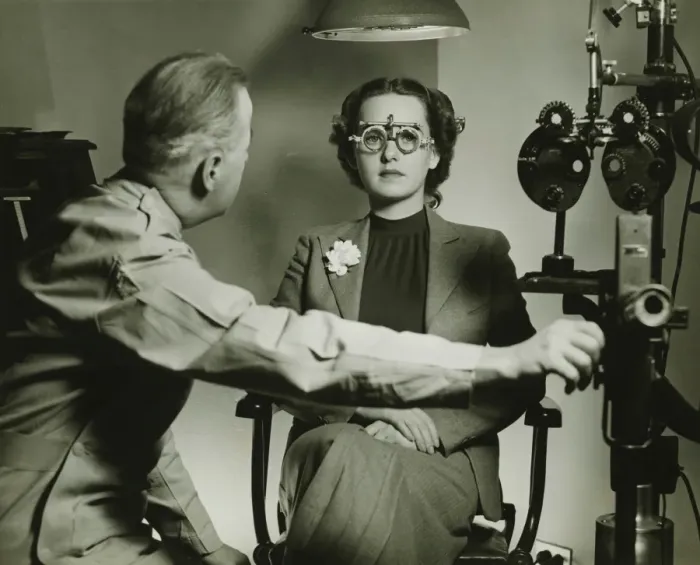 Framed Print : Optician examining patients eyes, (B&W) Framed Print : Optician examining patients eyes, (B&W)