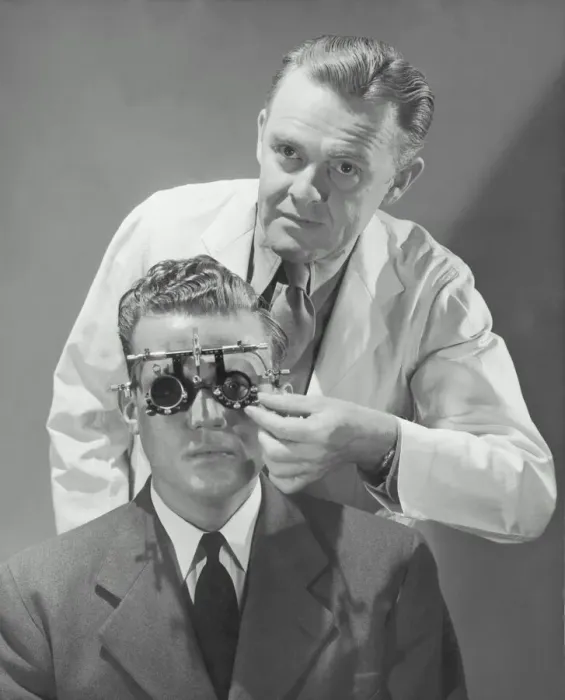 Framed Print : Optometrist giving man eye examination (B&W) Framed Print : Optometrist giving man eye examination (B&W)