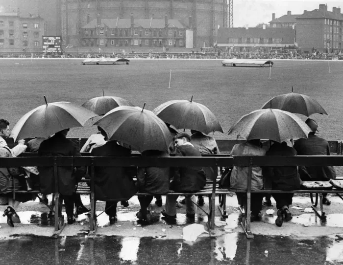 Framed Print : Oval Rain. circa 1946: A group of spectators sit underneath umbrellas in the rain Framed Print : Oval Rain. circa 1946: A group of spectators sit underneath umbrellas in the rain