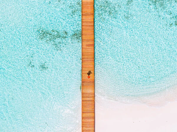 Overhead view of woman walking on jetty, Maldives