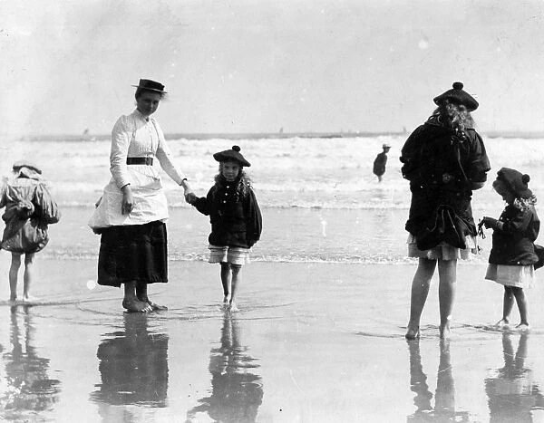 Paddling. Girls wearing tam o shanters paddling at the seaside