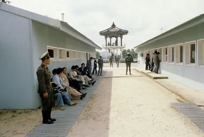 Framed Print : Panmunjom. Members of the press sitting in the shade of a building in Panmunjom