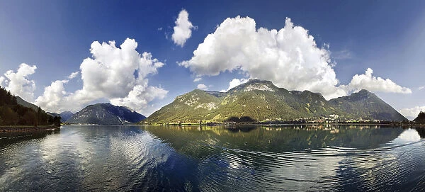 Panorama of Lake Achensee with the Rofan Mountains and bizarre clouds in the sky reflecting in the lake, Achensee, Tyrol, Austria, Europe