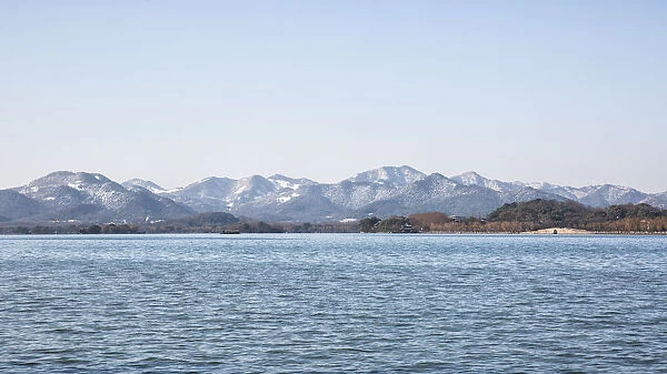 Panorama View of the West Lake against snow covered mountains, Zhejiang, China