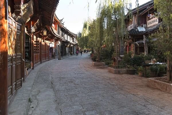 Panoramic view of Lijiang Old Town at sunset and some tourists walking by