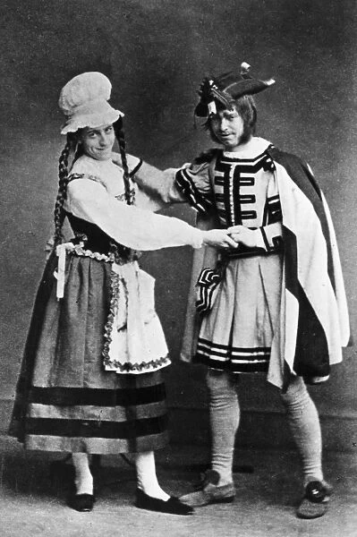 Pantomime. circa 1900: A pantomime dame and leading character, from an unknown production