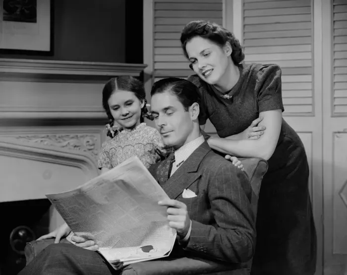 Framed Print : Parents with daughter (6-7 years) reading newspaper together