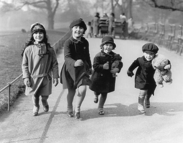 Park Life. Four children running through a park in England, circa 1930