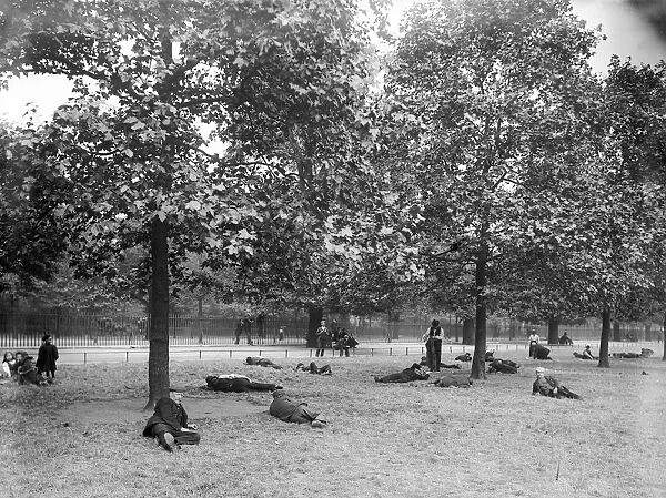 Park Rest. circa 1900: Unemployed men relax under the trees at St James Park in London