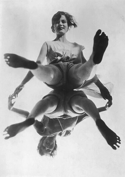 Pas De Deux. Two young women pose back-to-back on a pane of glass, circa 1930