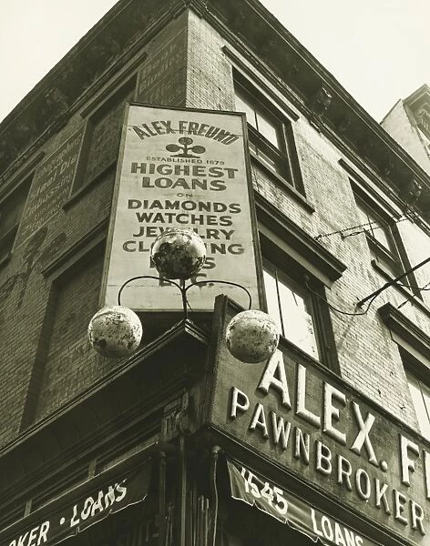 Pawnbroker sign on building corner, (B&W), low angle view