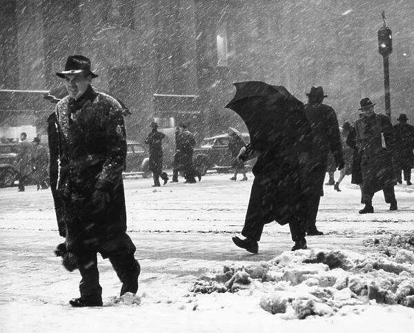 People crossing city street in snow stor