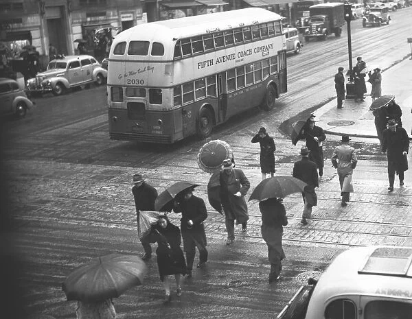 People crossing street in rain, (B&W), elevated view