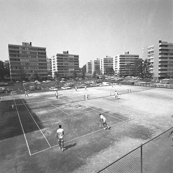 People playing tennis on court, (B&W), elevated view