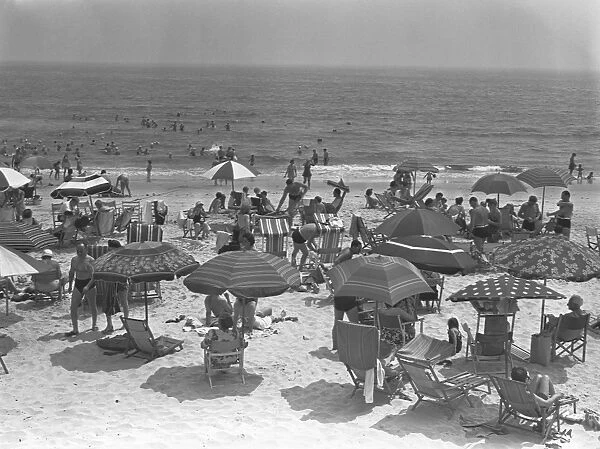 People relaxing on beach, (B&W), elevated view