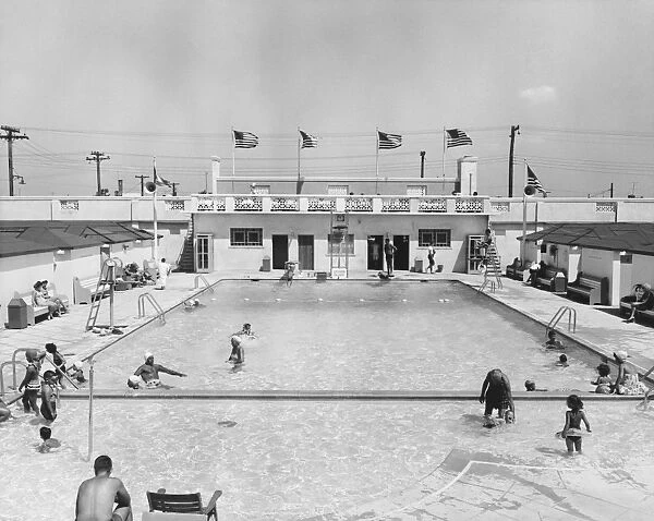 People relaxing in outdoor pool (B&W), elevated view