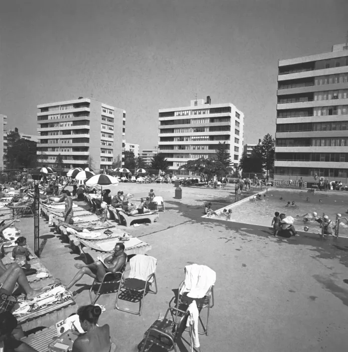Framed Print : People relaxing at swimming pool surrounded by apartment buildings, (B&W)