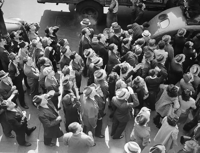 Framed Print : People on Street Look Up at Overhead Stunt