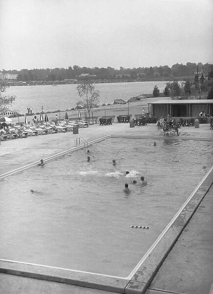 People swimming in outdoor pool, (B&W), elevated view
