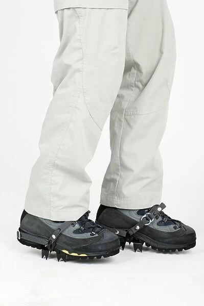 Person wearing boots with crampons, low section
