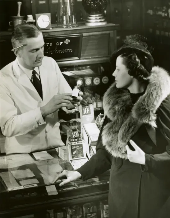 Framed Print : Pharmacist fills prescription for woman Framed Print : Pharmacist fills prescription for woman