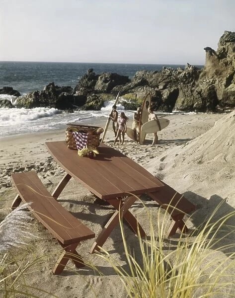 Picnic table with surfers on beach in background