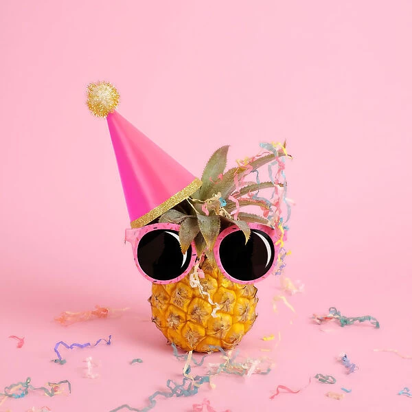 Pineapple wearing a party hat and sunglasses
