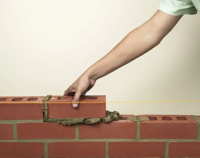 Framed Print : Placing a new brick on to fresh mortar on a wall Framed Print : Placing a new brick on to fresh mortar on a wall