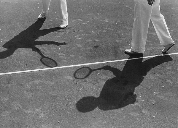 Playing Doubles. The shadows of two men playing a doubles game of tennis circa 1940 s