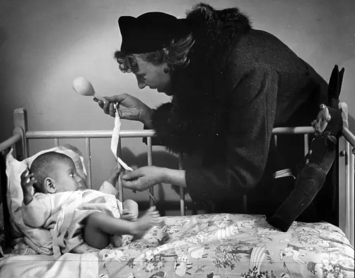 Framed Print : Playtime. 15th October 1938: A woman plays with a baby in a cot Framed Print : Playtime. 15th October 1938: A woman plays with a baby in a cot