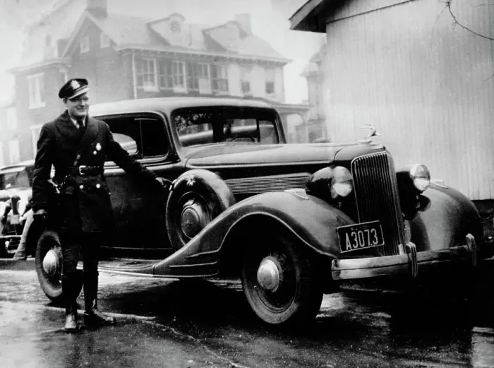 Framed Print : Police Officer With Bullet-Riddled Car Framed Print : Police Officer With Bullet-Riddled Car