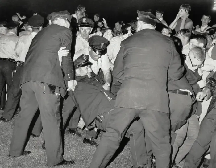 Framed Print : Police Pick Up Fallen Officer in Crowd