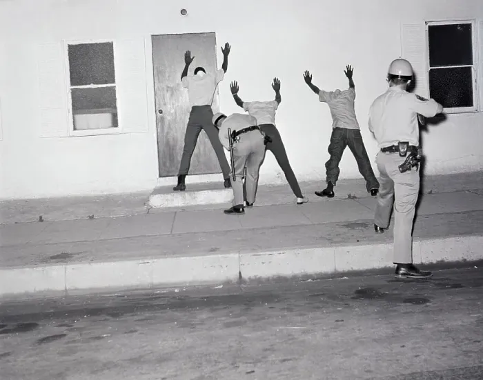 Framed Print : Police Searching Rioters Against Wall Framed Print : Police Searching Rioters Against Wall